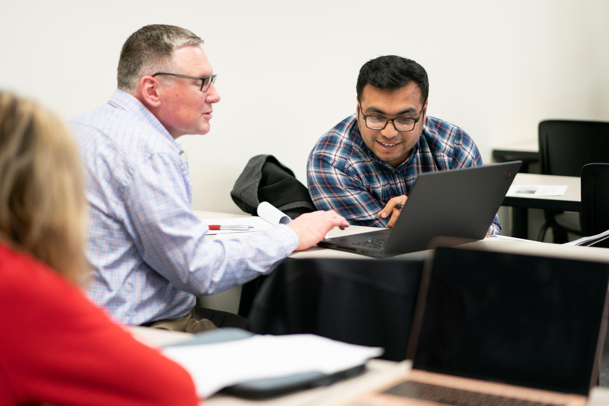 two adult learners looking at computers